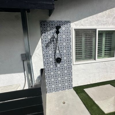 outdoor shower installation with patterned tile showers and black shower head